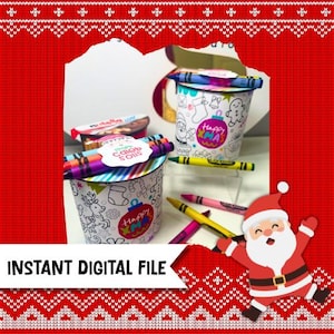 May include: Two white cylindrical containers with Christmas-themed line art, crayons, and a Nutella container. One container has a gingerbread man and ornament design, the other has a reindeer design. The text "Happy XMAS" and "Caleb Soils" are visible.