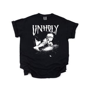 May include: Black t-shirt with a white graphic of a person snorting a substance, with the word "UNHOLY" above the image. The t-shirt has short sleeves and a crew neck.