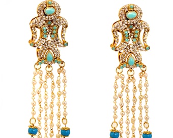 May include: A pair of gold earrings with a blue and white design. The earrings have a long, dangling chain with blue beads.