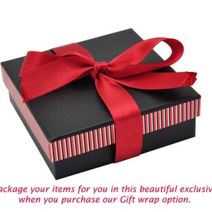 May include: A black gift box with a red ribbon tied in a bow. The box has red and white stripes around the edges.