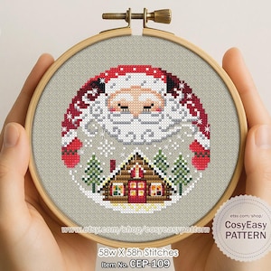 Könnte beinhalten: Ein Kreuzstichmuster mit dem Weihnachtsmann über einer Hütte und Bäumen, in einem hölzernen Stickrahmen. Das Design enthält rote, weiße und grüne Elemente, mit dem Text "CosyEasy PATTERN" und "58w X 58h Stitches".