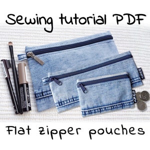 May include: Three denim zipper pouches of different sizes. The pouches are flat and have a blue denim fabric with a light wash. The largest pouch has a zipper pull with the word "Sewing tutorial PDF" written above it.