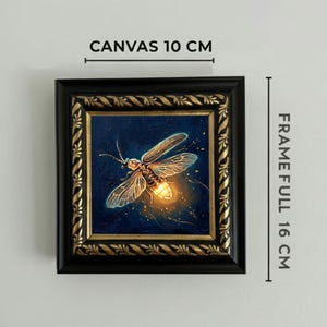 Puede incluir: Obra de arte enmarcada cuadrada que presenta una pintura detallada de una luci&eacute;rnaga con luz brillante. El lienzo mide 10 cm, y el marco completo mide 16 cm. El marco es negro con detalles dorados, sobre un fondo azul oscuro.