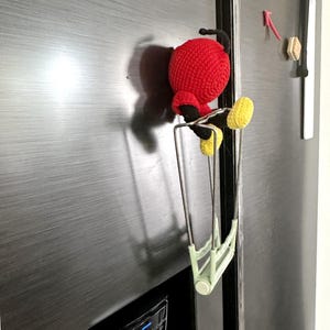 Finished magnetic hook surrounded by other fun crochet projects and supplies