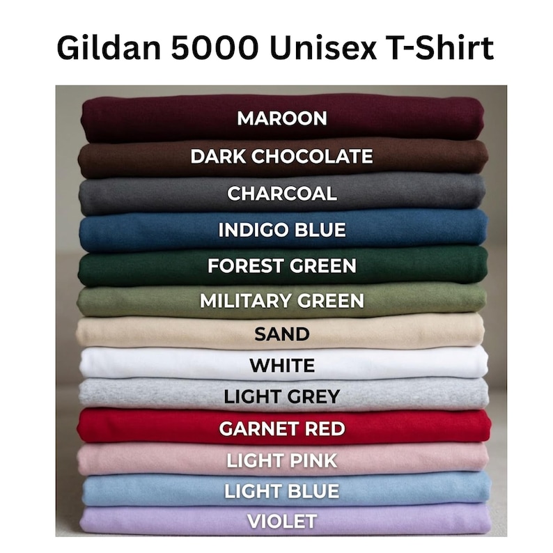 May include: A stack of Gildan 5000 unisex t-shirts in various colors including maroon, dark chocolate, charcoal, indigo blue, forest green, military green, sand, white, light grey, garnet red, light pink, light blue, and violet, labeled by color.