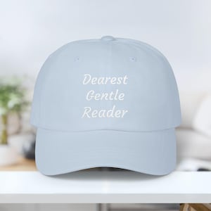 May include: A light blue baseball cap with the embroidered text "Dearest Gentle Reader" in white. The cap has a curved brim and a structured crown, suitable for casual wear.