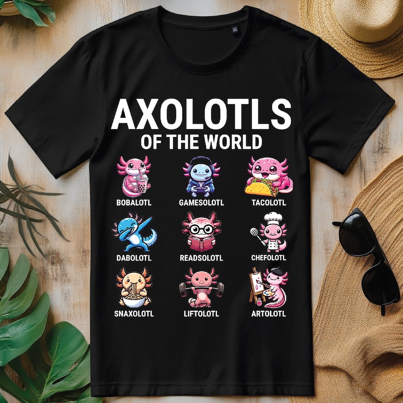 May include: Black t-shirt with the text "Axolotols of the World" and a grid of nine cartoon axolotls, each with a different activity or item, such as boba tea, tacos, and reading a book.