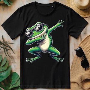 以下が含まれることがあります： 黒いTシャツに、サングラスをかけてダブをしている緑色のカエルが描かれています。