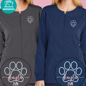 May include: Two zip-up jackets, one charcoal gray and one navy blue, with embroidered paw prints and the name "Kayla DVM". The jackets have a round neckline and two front pockets. The jackets are labeled "Embroidered".