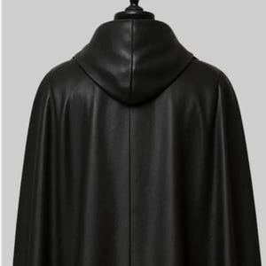 May include: A black leather cape with a hood, viewed from the back. The cape has a smooth texture and a flowing design. The hood is attached to the cape and is also made of black leather.