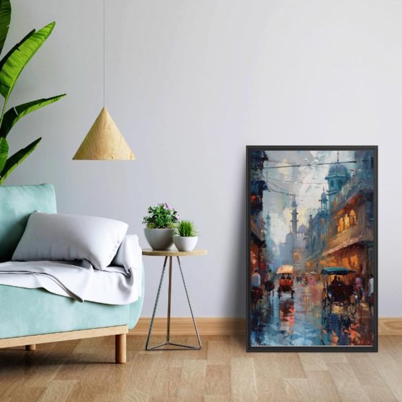 May include: A framed art print depicting a street scene with buildings, people, and horse-drawn carriages. The artwork features a palette of blues, browns, and oranges, with reflections on a wet surface.