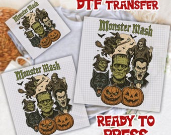 May include: DTF transfer sheets with a Halloween theme. The designs feature classic monsters, pumpkins, and the text "Monster Mash" and "Ready to Press". The transfers are printed on a grid-lined background.