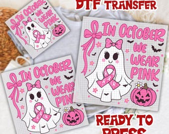 May include: Pink and white DTF transfer sheets with a ghost wearing a pink ribbon, a pink bow, and a pink pumpkin. The text "In October We Wear Pink" is displayed. The words "Ready to Press" are also visible.