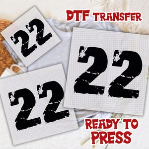 May include: Three DTF (Direct to Film) transfer sheets with the number 22 in a distressed black font. The transfers are on a grid-lined paper. The words "DTF TRANSFER" and "READY TO PRESS" are in red, heart-shaped text.