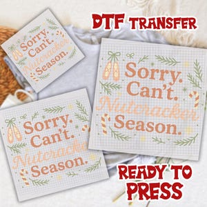 May include: Three DTF transfer sheets with the text "Sorry. Can't. Nutcracker Season." in orange, surrounded by green sprigs, ballet shoes, and candy canes. The words "DTF TRANSFER" and "READY TO PRESS" are also visible in the image.