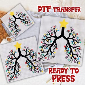May include: DTF transfer sheets featuring a black tree design with colorful lights, a yellow star, and the text "READY TO PRESS". The design is printed on a grid background.