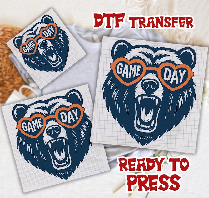 Pu&ograve; includere: Design di trasferimento DTF con un orso blu navy che indossa occhiali da sole arancioni a forma di cuore con le parole "GAME DAY". L'orso ha la bocca aperta ed &egrave; pronto per essere pressato. Sono visibili anche le parole "DTF TRANSFER" e "READY TO PRESS".