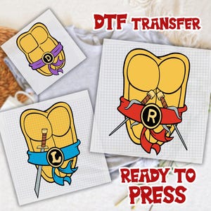 May include: Three DTF transfer designs featuring yellow turtle shells on grid paper. One shell has a purple sash with the letter D, one has a blue sash with a sword and the letter L, and one has a red sash with two sai weapons and the letter R.