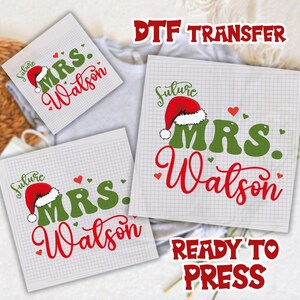 May include: DTF transfer sheets with the text "MRS. Watson" in red script and green block letters, topped with a Santa hat. The word "future" is above the hat. The words "DTF TRANSFER" and "READY TO PRESS" are also visible.