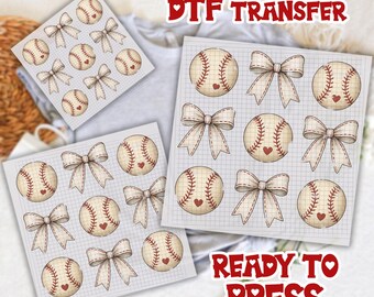 May include: DTF transfer sheets featuring baseballs with heart accents and bows on a grid background. The text "DTF TRANSFER" and "READY TO PRESS" are in red. The baseballs have red stitching.