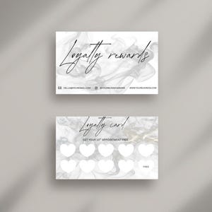 Può includere: Tessere fedeltà fronte-retro con un design fumoso e marmorizzato. La carta superiore recita "Loyalty rewards" in elegante scrittura. La carta inferiore è una tessera fedeltà con spazi a forma di cuore.