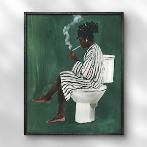 May include: A framed art print depicts a person in a striped robe sitting on a toilet, smoking. The artwork is set against a dark green background. The person is dark-skinned with dark hair. The robe has black and white stripes.