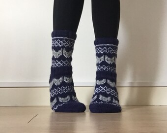May include: A pair of blue and white patterned socks with a cat design. The socks are made of a soft, knitted fabric.