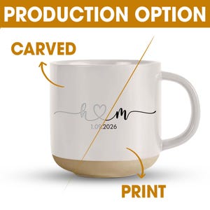 May include: White ceramic mug with a beige base and a curved handle. The mug features the initials "h♡m" in grey and black, with the date "1.09.2026" below. The words "PRODUCTION OPTION", "CARVED", and "PRINT" are also visible.