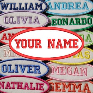 Op de afbeelding: Een verzameling ovale stoffen patches met geborduurde namen, waaronder "William", "Olivia", "Oliver", "Nathalie", "Gemma", "Andrea", "Leonardo", "Megan", en een blanco patch met de tekst "YOUR NAME".