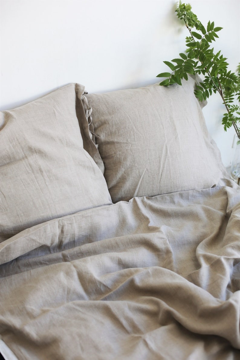 Puede incluir: Un juego de ropa de cama de lino beige con dos fundas de almohada y una funda n&oacute;rdica. La ropa de cama est&aacute; hecha de lino natural y tiene un aspecto relajado y casual.