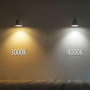 Puede incluir: Dos l&aacute;mparas colgantes iluminan paredes texturizadas, mostrando la diferencia entre las temperaturas de color de 3000K y 4000K. El lado izquierdo muestra un brillo c&aacute;lido y amarillento, mientras que el lado derecho emite una luz blanca m&aacute;s fr&iacute;a.