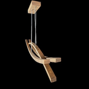 Puede incluir: Una moderna silla colgante de madera con un dise&ntilde;o minimalista. La silla est&aacute; suspendida del techo por finos cables plateados. El marco est&aacute; construido con madera clara y oscura, con elementos curvos y rectangulares.