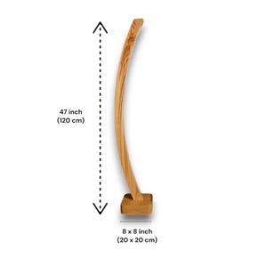 Op de afbeelding: Een gebogen houten sculptuur met een vierkante basis. De sculptuur is 120 cm hoog en de basis is 20 x 20 cm. Het hout heeft een natuurlijke nerf en een lichtbruine kleur.