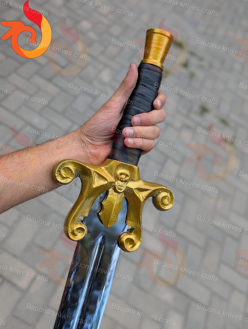 May include: A gold and silver sword with a skull design on the crossguard. The handle is wrapped in black material. The blade is silver and the hilt is gold. The sword is held in a hand.