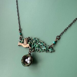 Hummingbird necklace with handwoven nest and eggs made of agate. Hanpainted filigree and Kingman turquoise accents.