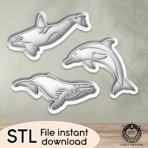 Op de afbeelding: Drie 3D-geprinte koekjesvormen in de vorm van een walvis, een dolfijn en een orka. De vormen zijn wit en hebben een gladde, glanzende afwerking. Direct downloaden van het STL-bestand.