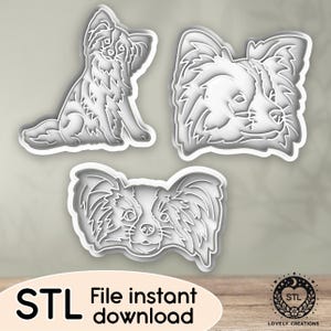 May include: Three white Papillon dog-shaped cookie cutters in various poses. The image includes the text "STL File instant download". The cutters are designed for baking or crafting.