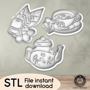 Op de afbeelding: Drie 3D-geprinte koekjesvormen in de vorm van een theepot, een theekopje met schoteltje en een theezakje met bladeren. De vormen zijn gemaakt van wit plastic en hebben een gedetailleerd ontwerp.