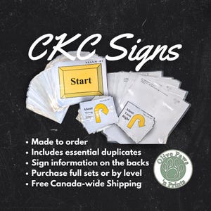 May include: A selection of CKC Signs, featuring "Start" and directional signs, presented in clear packaging. The signs have yellow and white backgrounds with black text. The image also includes the text "Made to order" and "Olive Paws 'n Prints" logo.