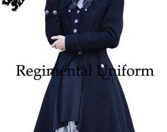 Puede incluir: Un abrigo de uniforme regimental azul marino oscuro con cuello alto, botones decorativos y falda acampanada. El abrigo presenta un diseño a medida con un panel a rayas en contraste y el texto "Regimental Uniform". Un escudo de armas es visible.