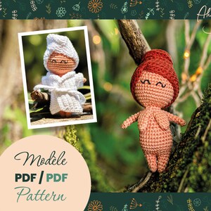 May include: A photo featuring two handmade crochet dolls. One doll is nude with red hair, and the other is wearing a white robe and hood. The image includes the text "Modele PDF / PDF Pattern" and the name "Ahookamama".