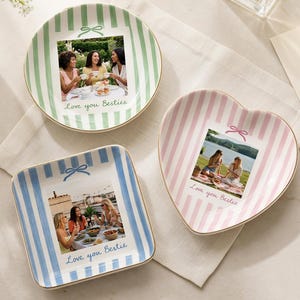 May include: Three ceramic trinket dishes with gold-toned rims, featuring vertical stripes in green, pink, and blue. Each dish displays a custom photograph of friends and the text "Love you Besties" with a small bow graphic printed above the photo.