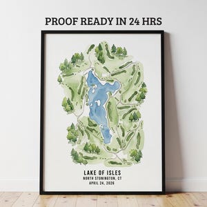 May include: A framed watercolor map of Lake of Isles in North Stonington, CT, featuring a blue lake surrounded by green golf course fairways and trees. The text "PROOF READY IN 24 HRS" is at the top, and the lake's name and date are at the bottom.