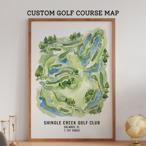 May include: A framed watercolor map of the Shingle Creek Golf Club in Orlando, FL. The map features a green and blue course layout with trees and water features. The text "CUSTOM GOLF COURSE MAP" is at the top, and the course details are at the bottom.