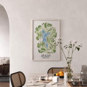 May include: A framed watercolor map of Lake of Isles golf course in North Stonington, CT, featuring a blue lake surrounded by green fairways and trees. The text "Lake of Isles" and date are visible.