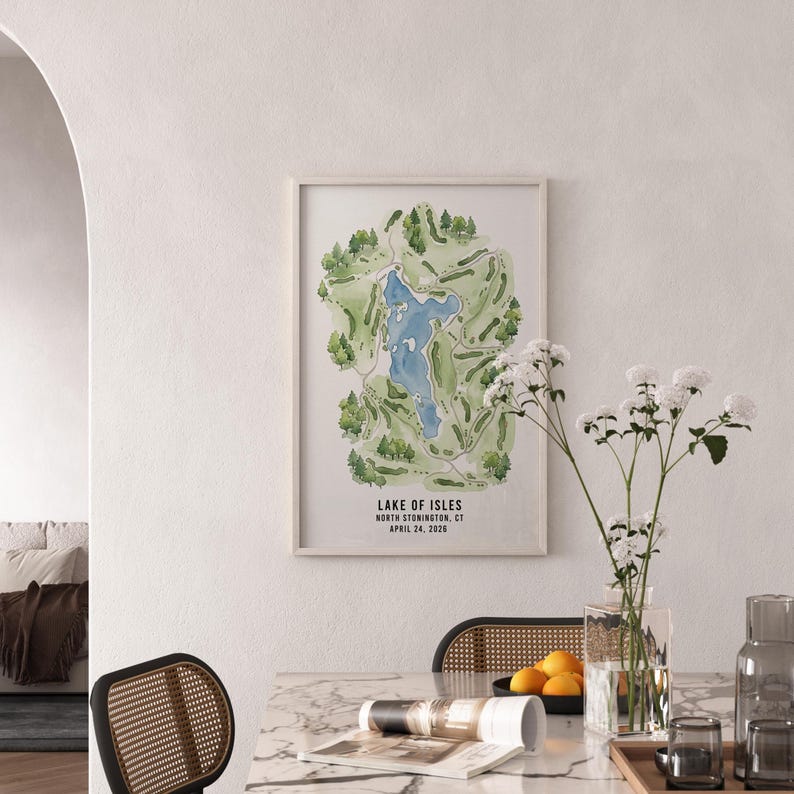 May include: A framed watercolor map of Lake of Isles golf course in North Stonington, CT, featuring a blue lake surrounded by green fairways and trees. The text "Lake of Isles" and date are visible.