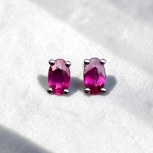 May include: A white ceramic mug with a black handle and the text "But First, Coffee" in a bold, black font. The mug is set against a blurred background, suggesting a cozy setting.