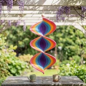 May include: A hanging spiral wind spinner featuring a vibrant crochet pattern with concentric rings of pink, orange, yellow, light blue, and purple. The structure consists of three connected, twisted sections suspended from a thin chain with a wooden bead.