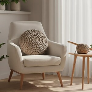 Puede incluir: Escena de sal&oacute;n de tonos neutros con un sill&oacute;n beige y un coj&iacute;n redondo tejido. Una peque&ntilde;a mesa auxiliar de madera sostiene un ovillo de lana y un ganchillo. Las plantas en macetas a&ntilde;aden vegetaci&oacute;n, creando un ambiente acogedor.
