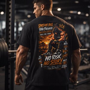 Könnte beinhalten: Schwarzes T-Shirt mit einem motivierenden Grafikdesign, das eine muskulöse Figur mit Kapuze vor einem Sonnenuntergang zeigt. Das Shirt enthält den Text "DREAM BIG, STAY FOCUSED, NO RISK NO STORY" und weitere inspirierende Sätze.